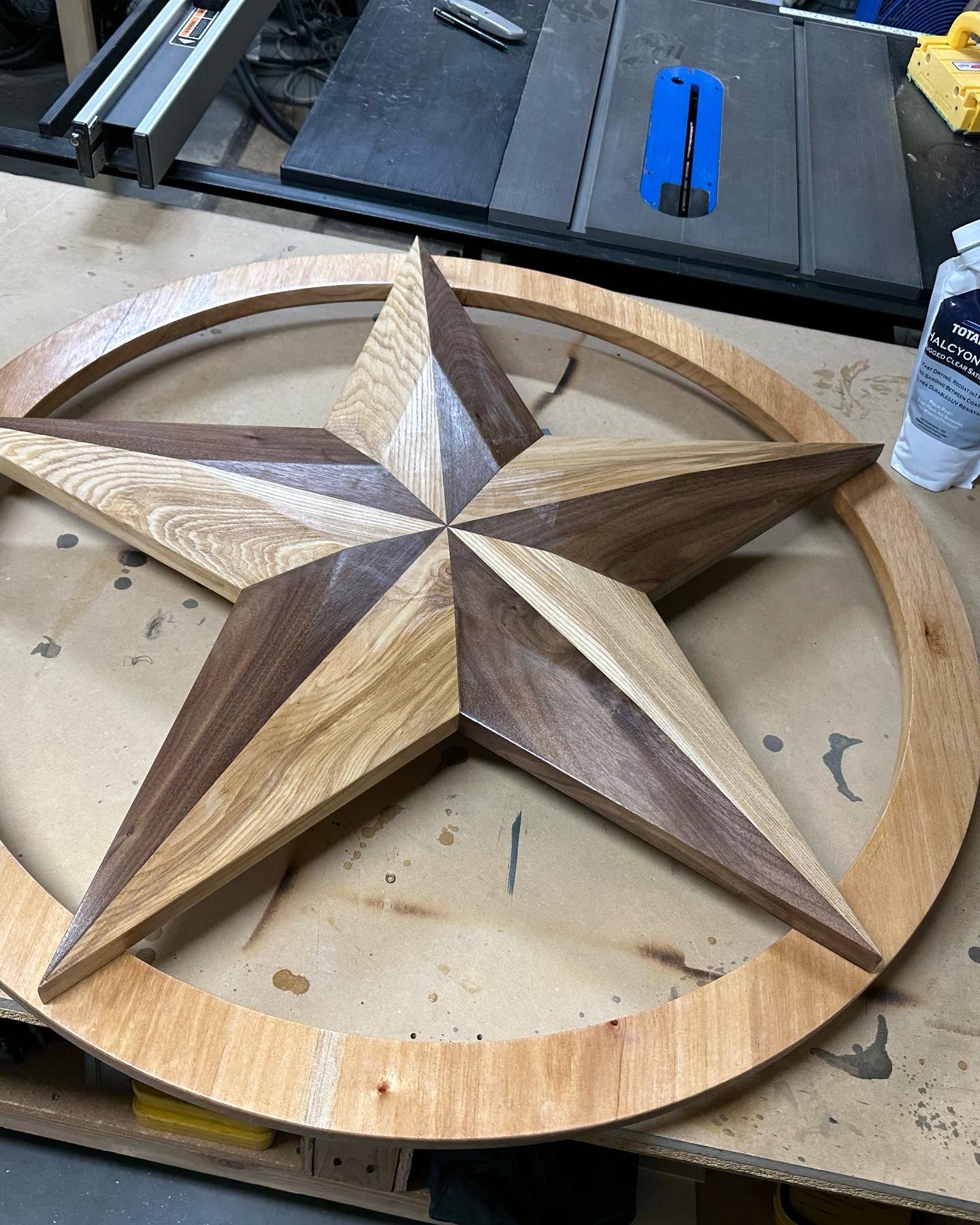 Custom Wooden Texas Star for home decor. Texas Star is made from walnut and white ash with a s Spanish cedar ring. This custom order piece is approximately three feet in diameter with 30 degree bevels. Total Boat Halcyon was used as the top coat varnish for added protection against weather and UV damage. Are you interested in ordering custom wood furniture or woodcraft? Please visit our contact page.