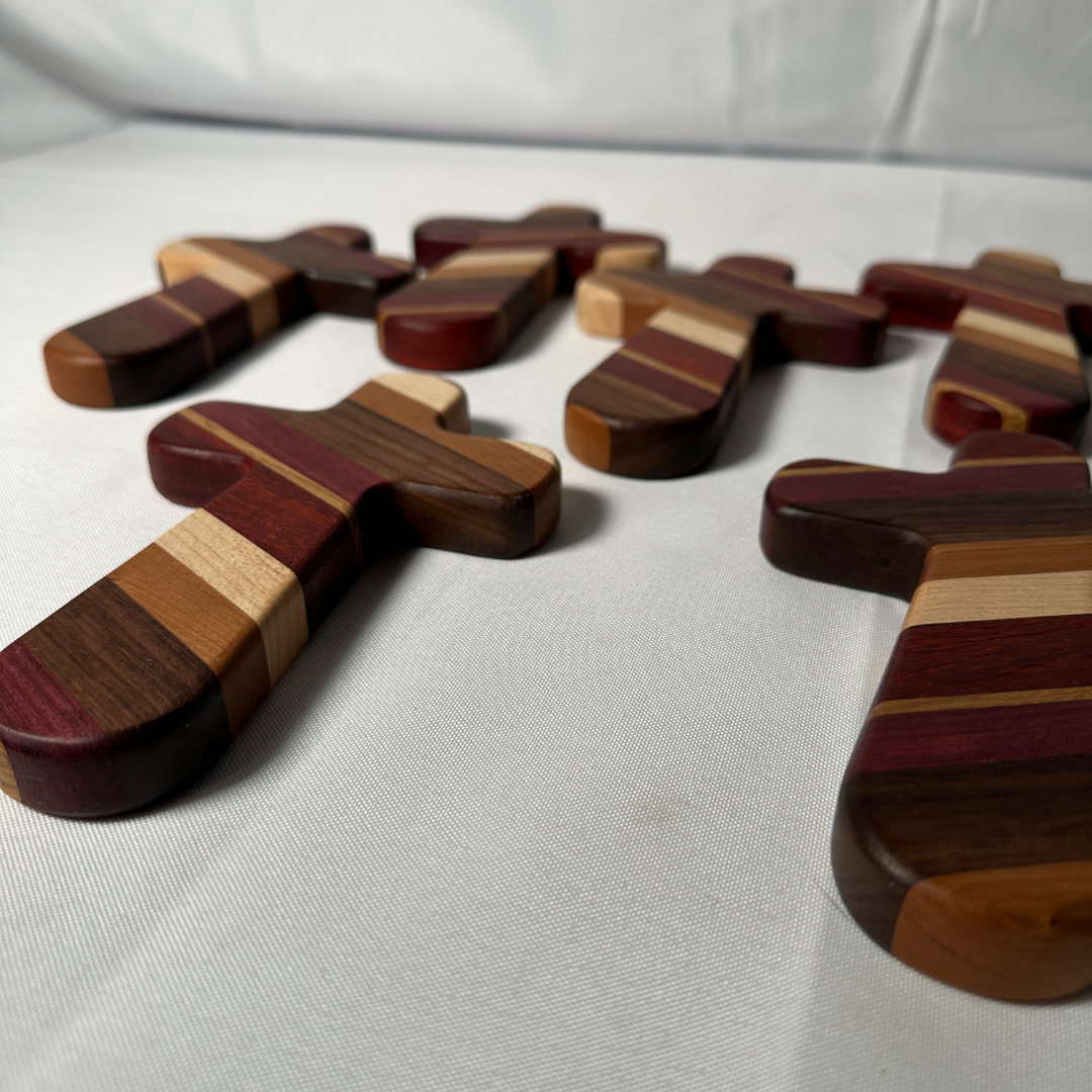 Add a timeless touch of faith and artistry to your home with this handcrafted wooden cross. Measuring 6-1/2" long by 4-1/8" wide, this cross is carefully crafted from premium strips of purple heart, paduak, white oak, hard maple, walnut, and cherry woods. Each cross is a unique piece, showcasing the natural beauty and rich tones of these high-quality hardwoods.
