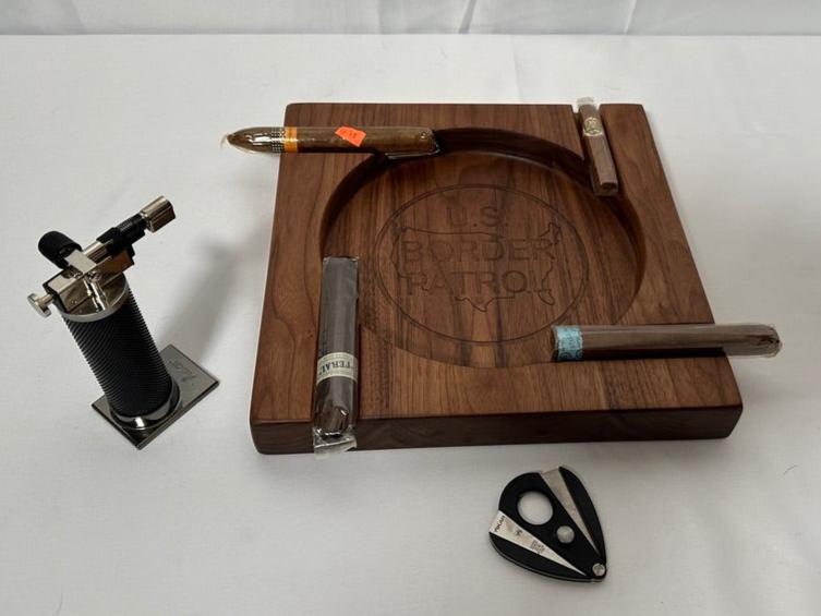 Elevate your cigar experience with this handcrafted Four-Person Solid Walnut Cigar Tray, featuring a stunning epoxy inlay of the US Border Patrol logo. Measuring 12" x 12" and 1.5" thick, this elegant tray is designed to hold up to four cigars, making it perfect for shared moments and celebrations. The rich, natural beauty of solid walnut combined with the precision epoxy inlay creates a luxurious and patriotic centerpiece for any gathering.